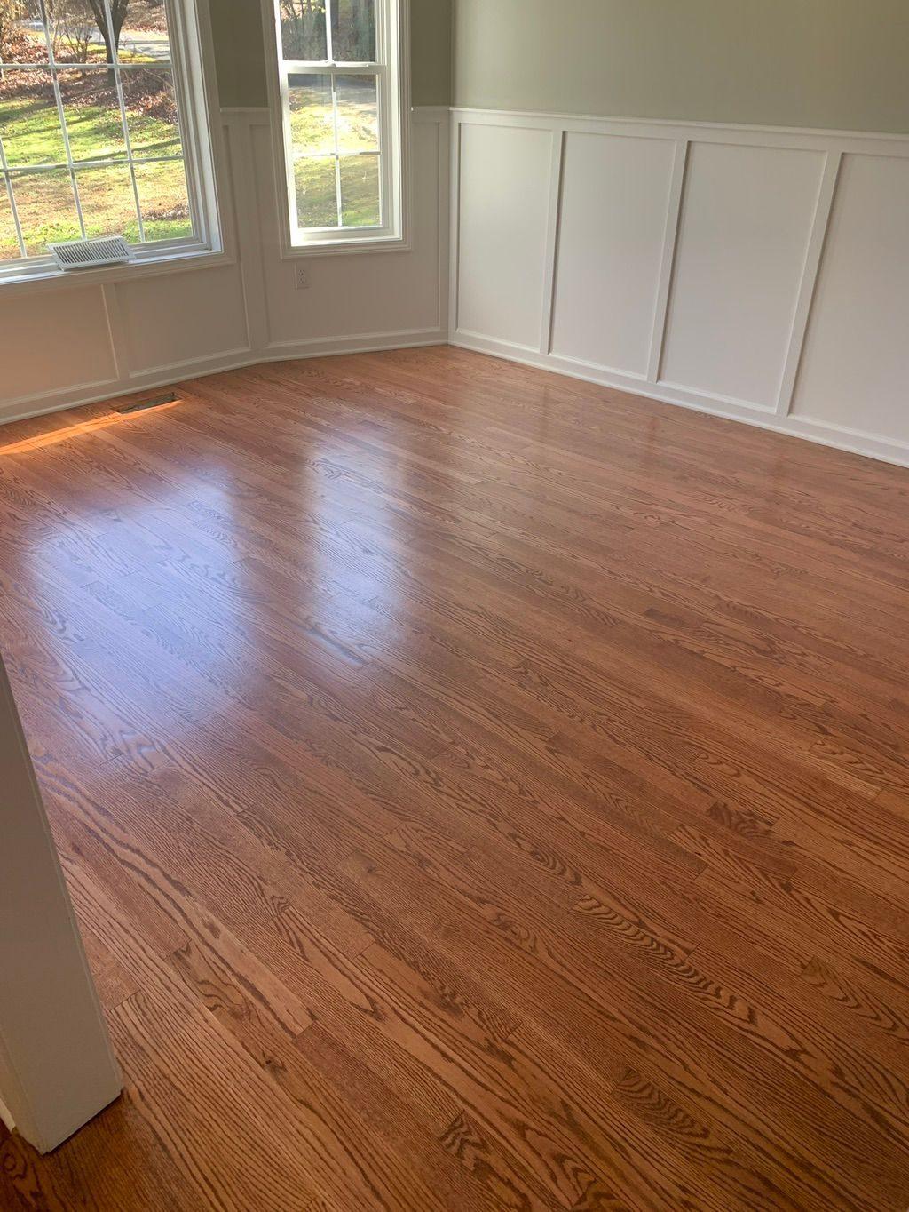 Glossy red oak floor in a bright room with board-and-batten walls