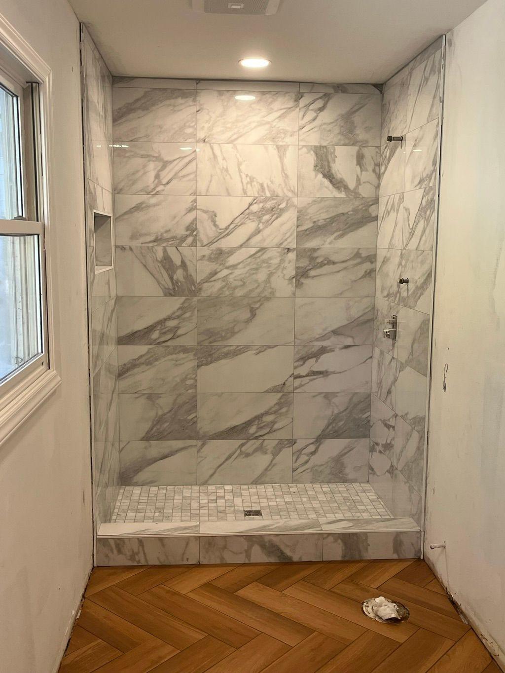 Marble-look porcelain shower with a tiled niche